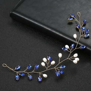 Dettaglio di un accessorio per capelli da sposa con cristalli blu e perle bianche