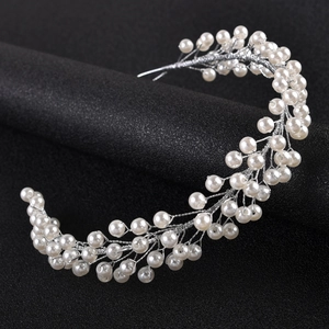 Close-up of handmade silver bridal hair vine with white pearls and crystals
