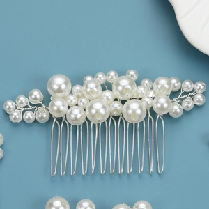 Handmade bridal hair comb with elegant white pearls and silver wire on blue background