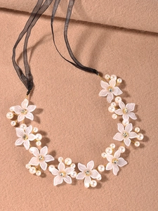 Détail de fleurs en acrylique blanc avec perles et liens en ruban d'organza noir