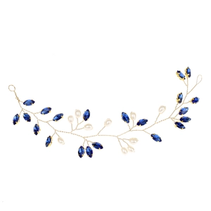 Dettaglio di un tralcio per capelli da sposa in filo dorato con cristalli blu