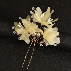 Detail of handmade bridal hair fork with yellow tulle flowers and pearl beads