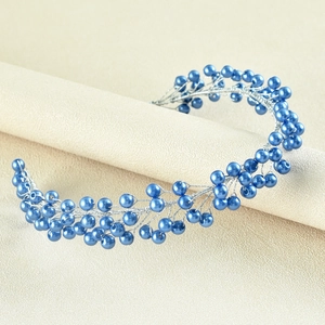 Detailed close-up of handmade bridal headpiece with navy blue pearls and silver wires