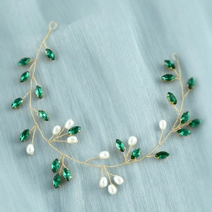 Dettaglio dell'accessorio capelli sposa dorato con cristalli verdi e perle