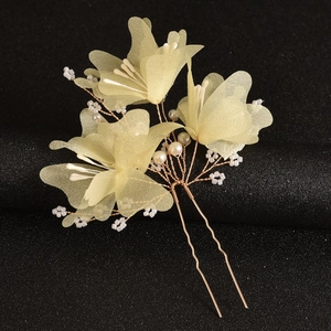 Detailed macro view of handmade bridal hair pins with yellow tulle flowers and white pearls
