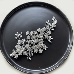 Silver bridal hair vine with shimmering crystals and rhinestones on black display
