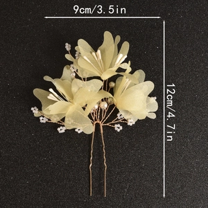Macro detail of handmade bridal hair fork with yellow gauze flowers and small pearls