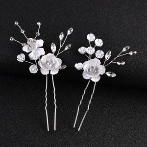 Détail d'épingles à cheveux fleurs blanches émaillées avec perles et cristaux de mariage
