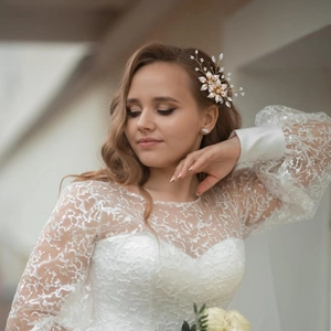 Bijou de tête de mariée doré avec perles blanches et strass sur un voile de mariage élégant