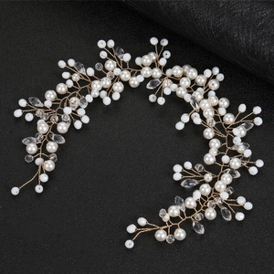 Detail of bridal hair vine with white pearls and crystals on gold wire over black leather