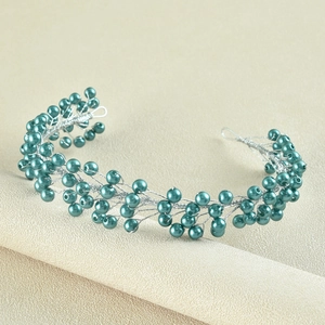 Close-up of handmade teal pearl and silver wire bridal headband with branch design
