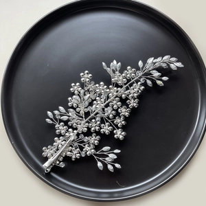 Silver bridal flower hair clip with crystal beads on a black textured background