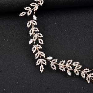 Elegant gold leaf bridal headband with shimmering crystals and leaf-shaped gemstones