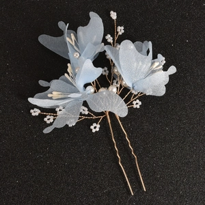Close-up of handmade bridal hair pin with blue organza flowers and faux pearls