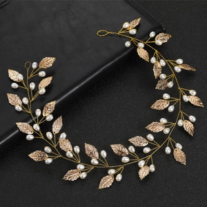 Gold leaf and pearl bridal hair vine accessory for weddings on a black background