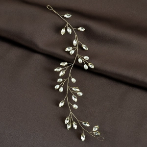 Dettaglio macro di tralcio per capelli da sposa con cristalli e perle su seta scura