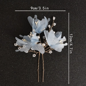 Detailed macro of handmade light blue floral hair pin with pearls and golden wire