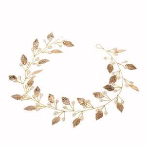Handmade bridal hair vine with golden metal leaves and white faux pearls on white background