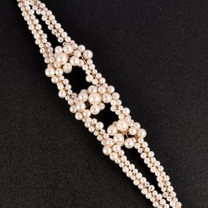 Elegant pearl wedding headband with white beads and gold wire on a black background