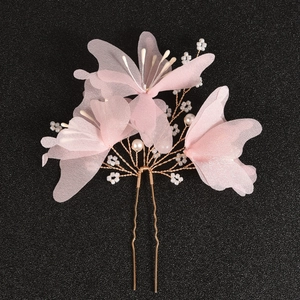 Detail of pink fabric flower bridal hair pin with golden metal base and white beads