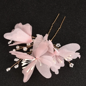 Detail of pink tulle butterfly hair pins with pearls and golden wire for wedding styling