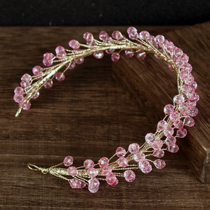 Detail of handmade bridal headband with pink crystals and twisted gold wire
