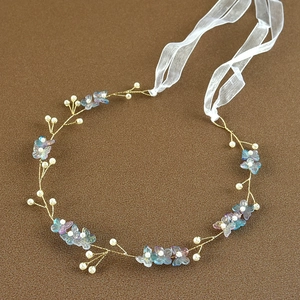Detailed close-up of handmade bridal headband with gold wires, pearls, and butterfly petals