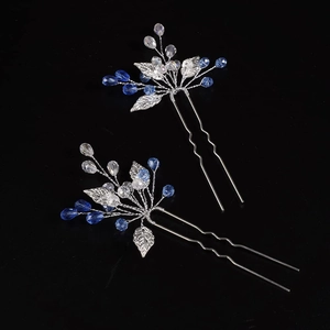 Silver bridal hair pins set with blue crystal beads and metallic leaves on black backdrop