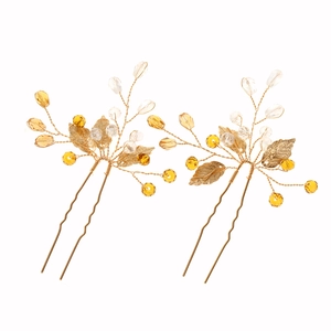 Detail of 2-piece set golden leaf hair pins with amber crystal beads on white background