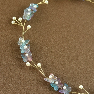 Detailed close-up of handmade bridal headband with pearls and colorful resin butterflies