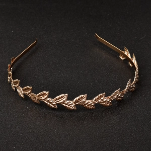 Detailaufnahme des goldenen Metall-Haarreifens mit Lorbeerkranz-Design auf schwarzem Grund