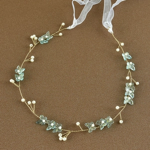 Detail of bridal headband with blue butterfly beads and white pearls on gold wire