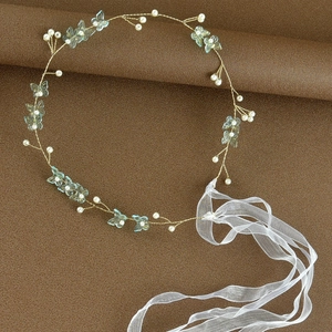 Detail of bridal headband with gold wires, pearls, blue butterflies and organza ribbons