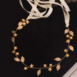 Goldenes Braut-Stirnband mit Metallblättern, Perlen und weißem Satin-Bindeband