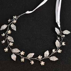 Eleganter Brauthaarschmuck mit silbernen Blättern und Perlen auf schwarzem Grund