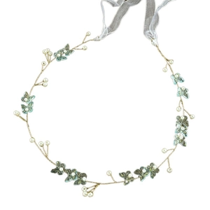 Macro view of handmade bridal headband with white pearls and iridescent butterfly charms