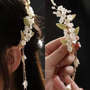 Pince à cheveux florale élégante avec pétales blancs et longs glands dorés