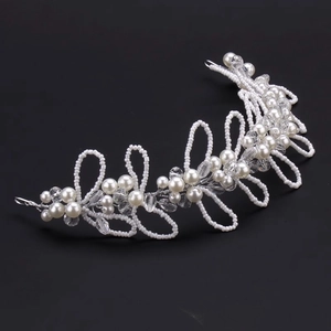 Elegant bridal hair vine with white pearls and crystals on a dark background