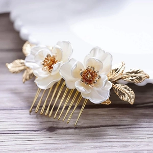 Détail du peigne de mariée avec lotus blancs, étamines dorées et feuilles texturées