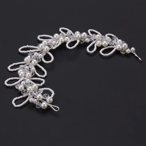 Elegant bridal hair vine with white pearls and silver wire on a black background