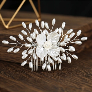 Détail du peigne à cheveux de mariée avec fleurs en résine et perles sur fil d'argent