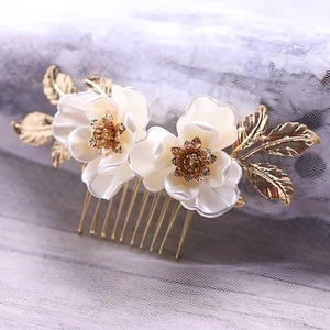 Peigne à cheveux de mariée avec lotus blanc et feuilles dorées sur fond de dentelle