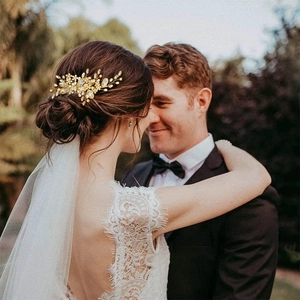 Détail d'un peigne à cheveux de mariée doré avec perles et cristaux sur un chignon