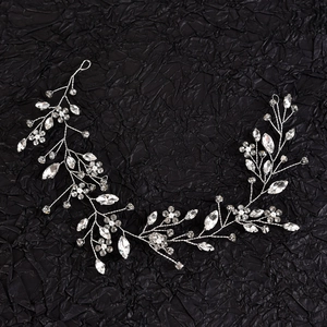 Macro shot of silver wedding hair vine with clear crystals and white faux pearls decor