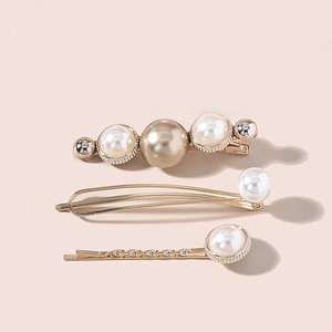 Three-piece golden pearl hair clip set with minimalist beaded pins on pink background