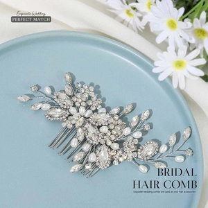 Peigne à cheveux de mariée argenté avec strass et perles sur un plat en céramique bleue