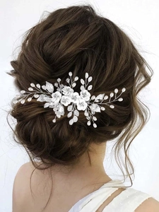 Vue détaillée des fleurs blanches en argile et des perles sur ce peigne de mariée