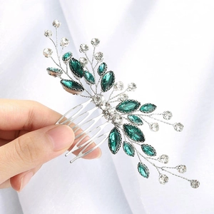 Detailed shot of handmade bridal hair comb with green rhinestones and silver metal branches