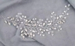 Silver bridal vine headband with pearls and crystals on a grey textured background