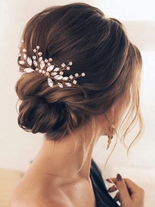 Elegant rose gold bridal hair comb with marquise crystals in a low bun hairstyle